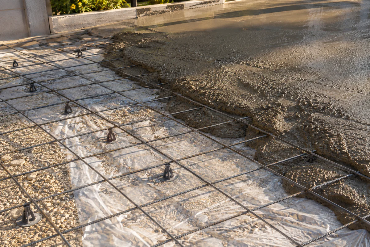 Photographie professionnelle d'un chantier de terrasse en béton montrant un treillis soudé en acier positionné sur cales au-d